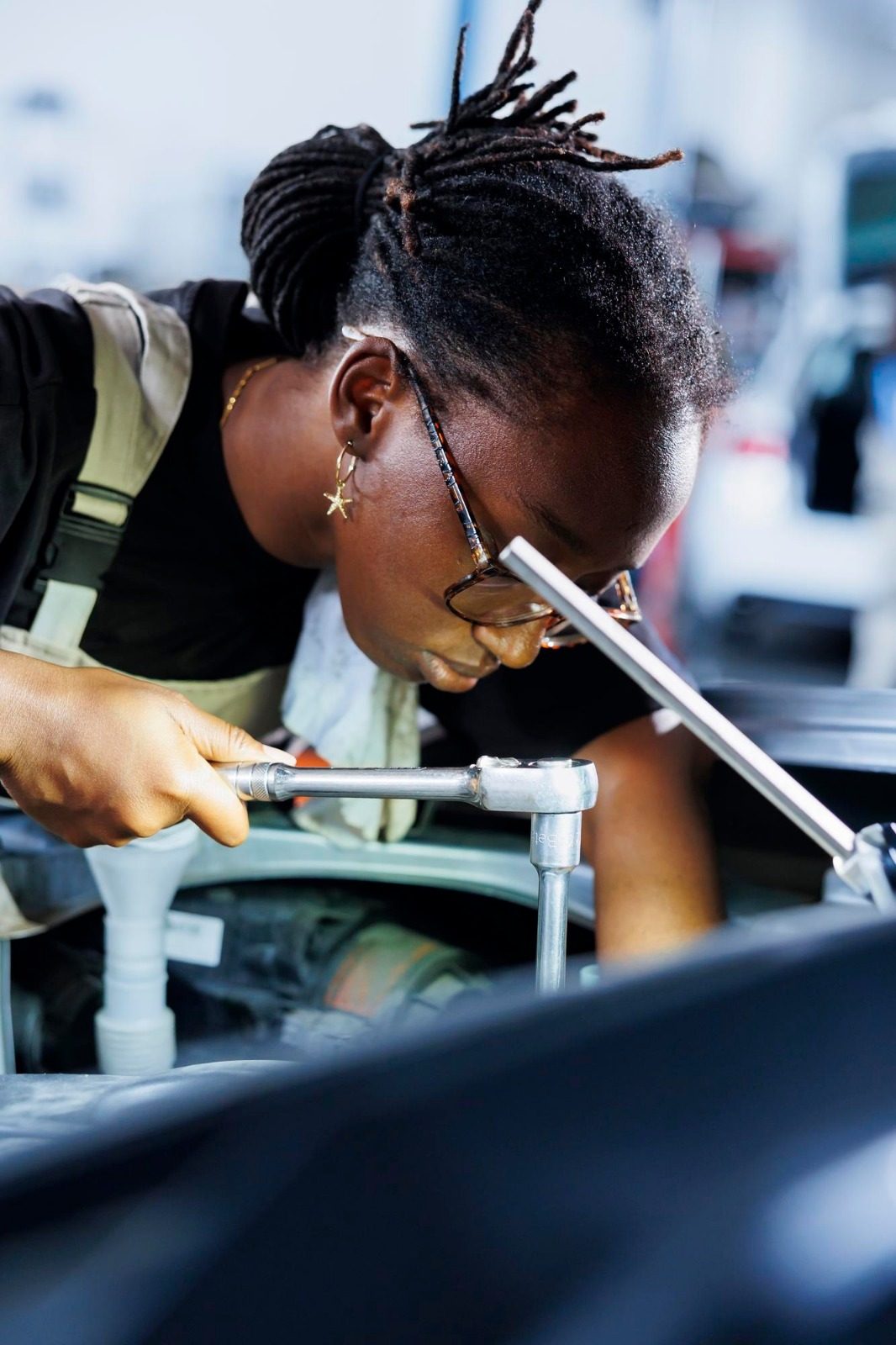 A young technician using a socket wrench on an engine